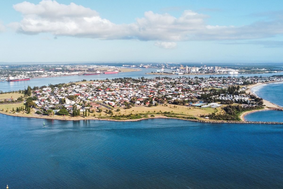 Aerial view of a harbourside suburb with ships and the port across the water